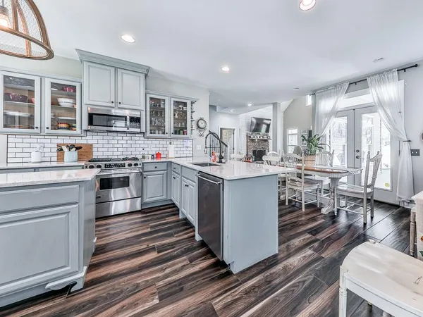 a large kitchen with stainless steel appliances kitchen island granite countertop a stove and a sink