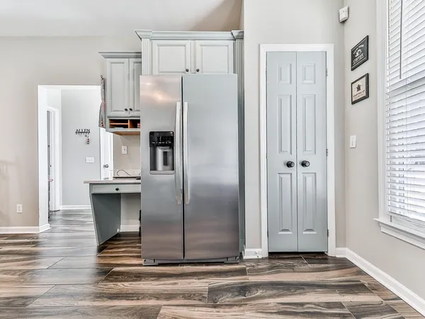 a metallic refrigerator freezer sitting inside of a kitchen