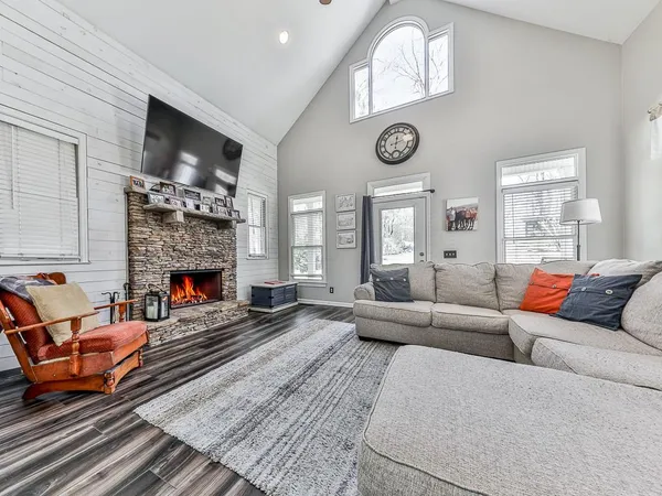 a living room with furniture a fireplace and a large window