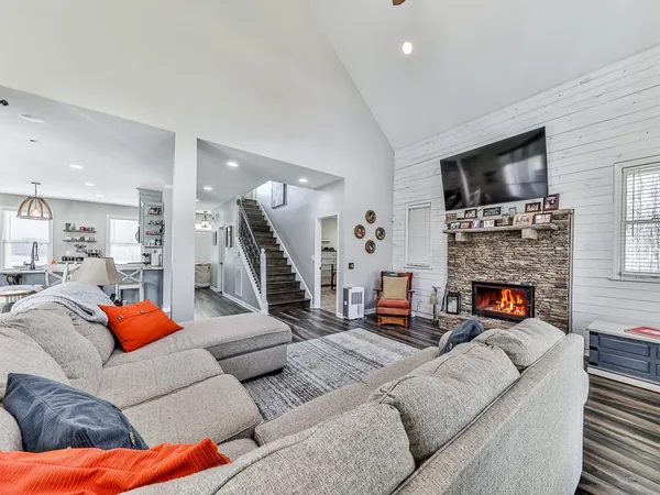 a living room with furniture a flat screen tv and a fireplace
