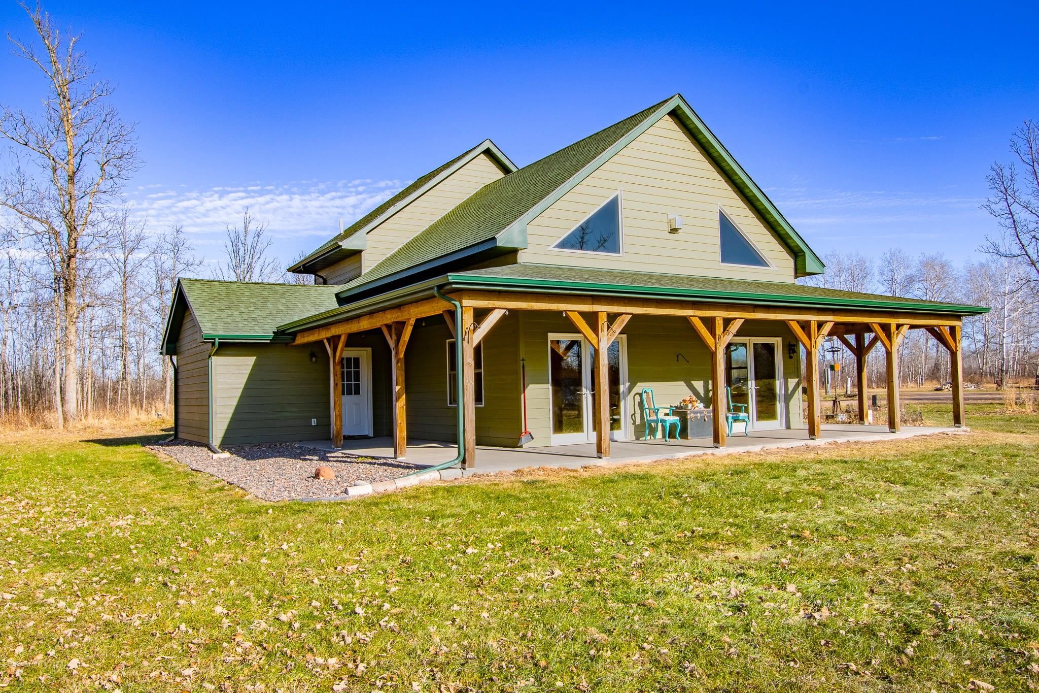 6014 Brown Road Kettle River, MN 55757 - Photo 2 of 54 Back of house with a large porch, roof with shingles, and a yard