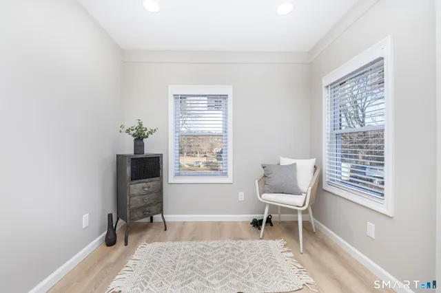 a kitchen with a refrigerator stainless steel appliances wooden floor cabinets and a window