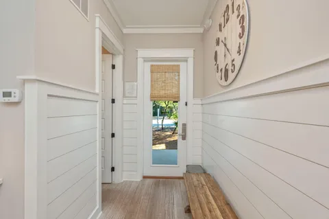 a view of a hallway with wooden floor and a window