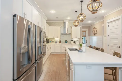 a kitchen with stainless steel appliances white cabinets and a refrigerator