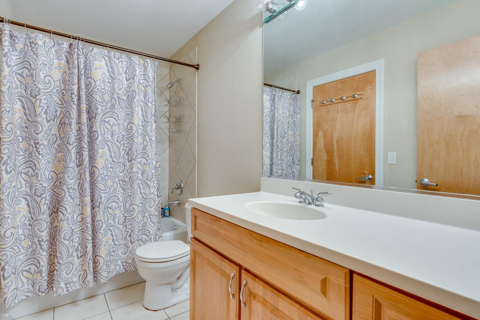 1500 West Monroe Street, Unit 122 Chicago, IL 60607 - Photo 12 of 14 a bathroom with a sink a toilet and shower curtain