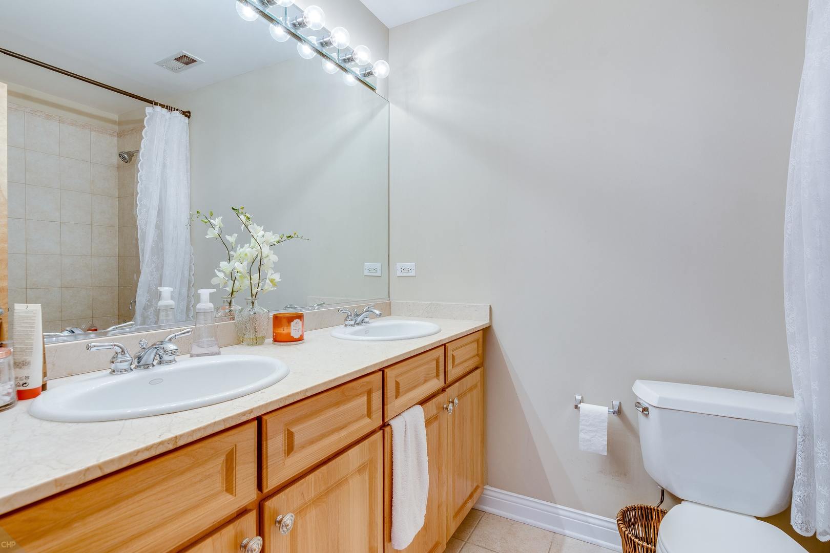 1500 West Monroe Street, Unit 122 Chicago, IL 60607 - Photo 14 of 14 a bathroom with a sink a toilet a mirror and shower