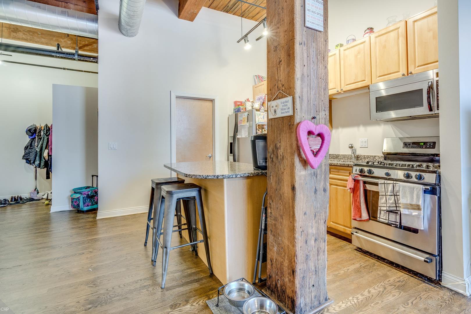 1500 West Monroe Street, Unit 122 Chicago, IL 60607 - Photo 5 of 14 a view of a kitchen with stainless steel appliances kitchen island granite countertop a refrigerator and a stove top oven
