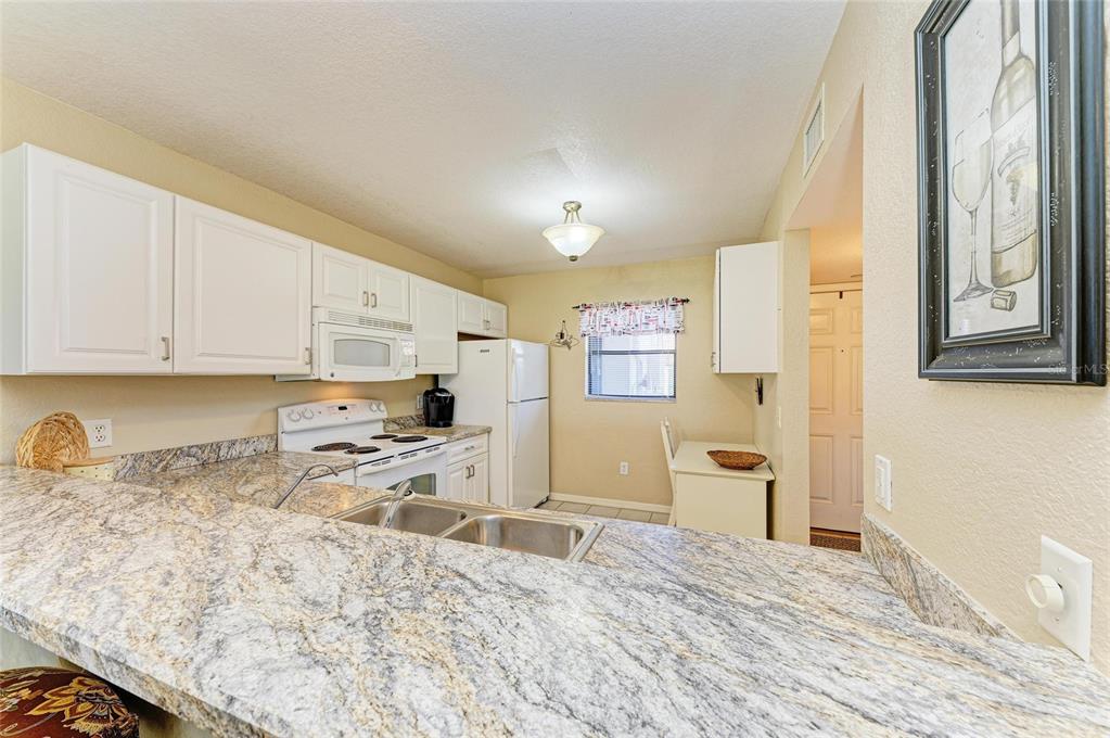 175 Kings Highway, Unit 1114 Punta Gorda, FL 33983 - Photo 12 of 64 a kitchen with stainless steel appliances granite countertop a refrigerator sink and cabinets