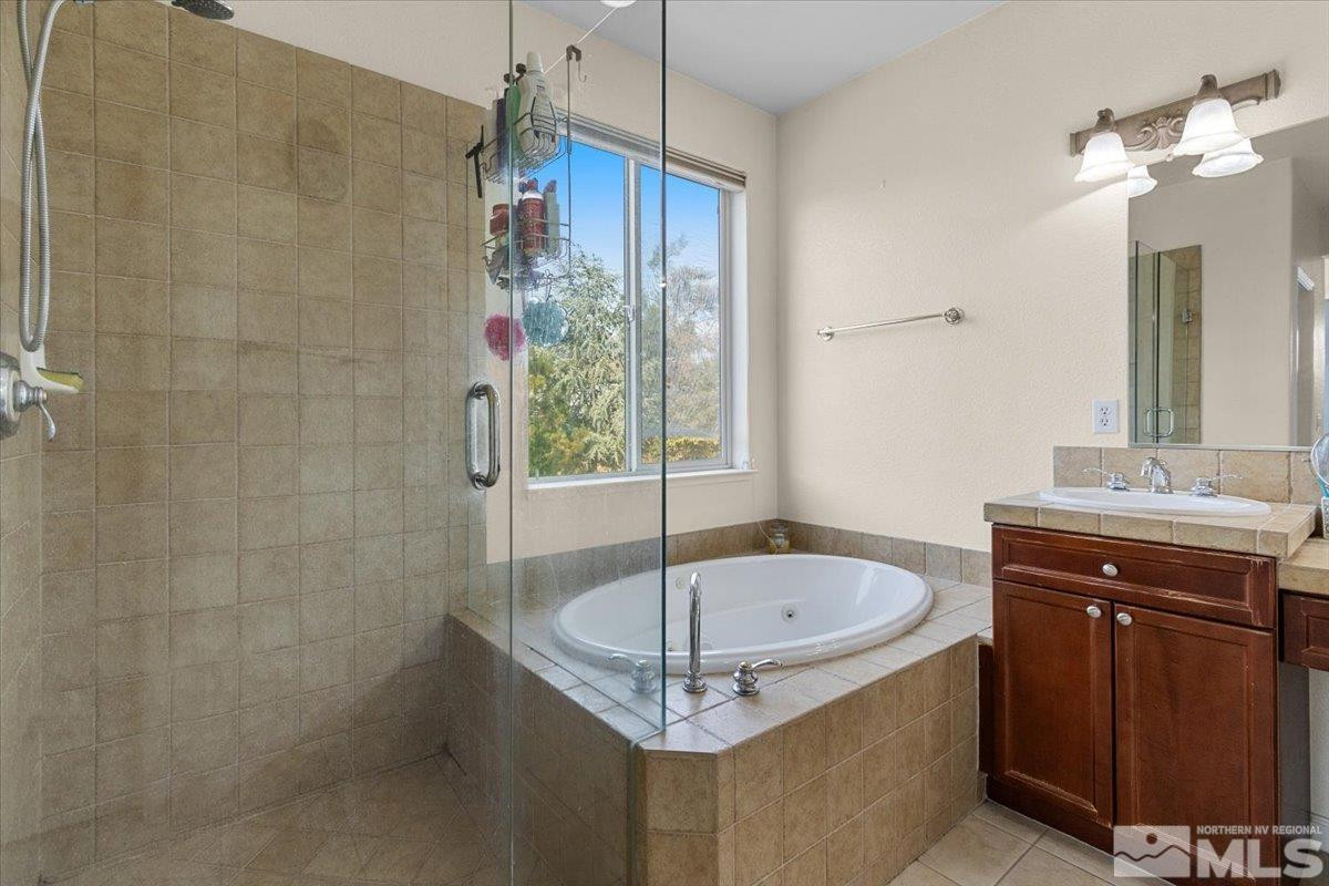 2540 Perryville Drive Reno, NV 89521 - Photo 17 of 27 a bathroom with a granite countertop sink a mirror and a bathtub