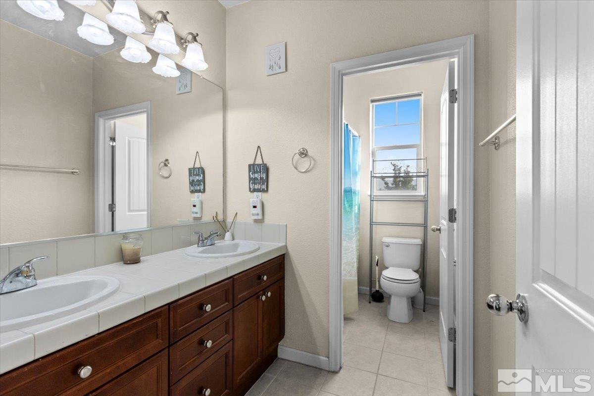2540 Perryville Drive Reno, NV 89521 - Photo 18 of 27 a spacious bathroom with a granite countertop sink a toilet and a mirror
