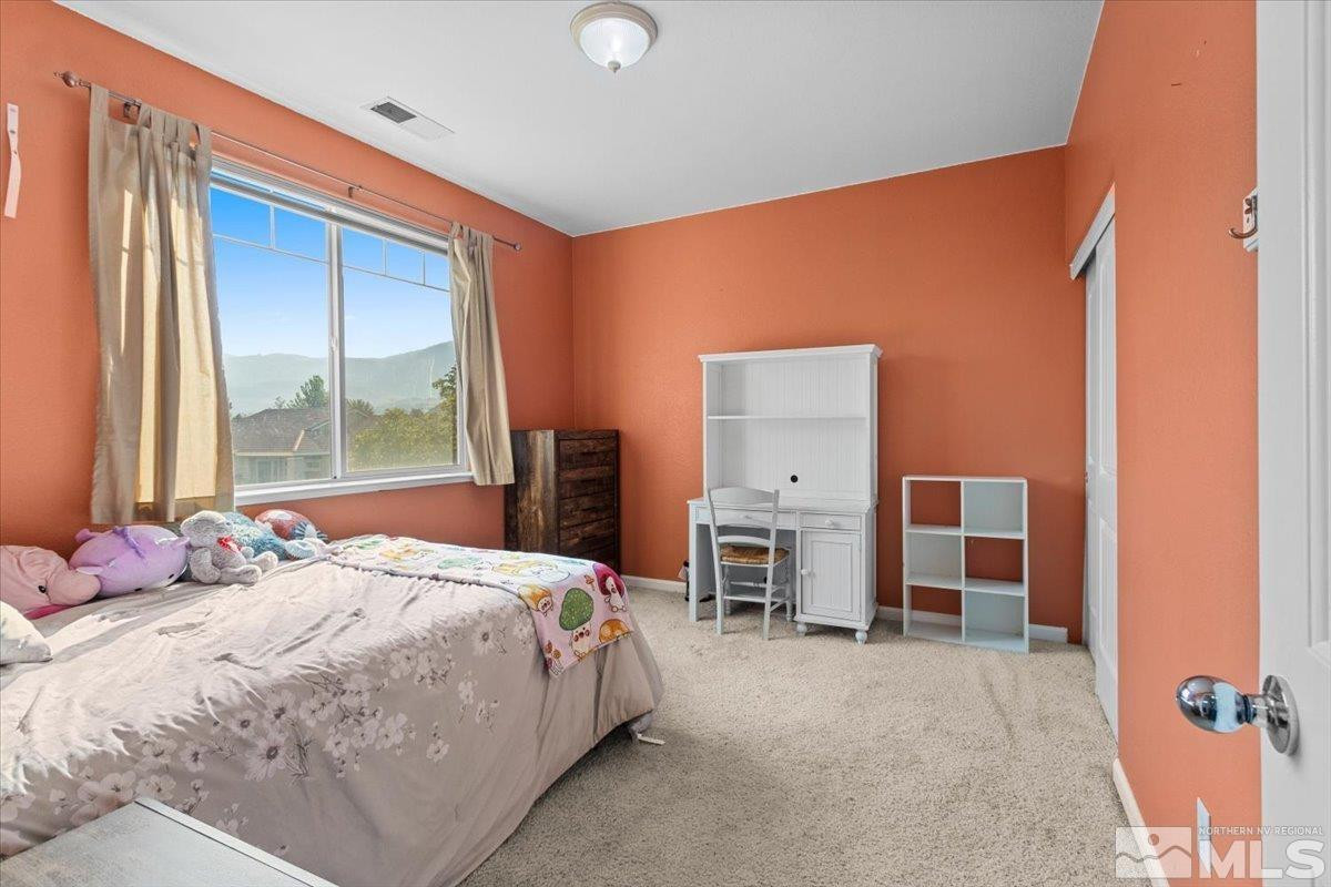 2540 Perryville Drive Reno, NV 89521 - Photo 21 of 27 a bedroom with a bed dresser and a large window