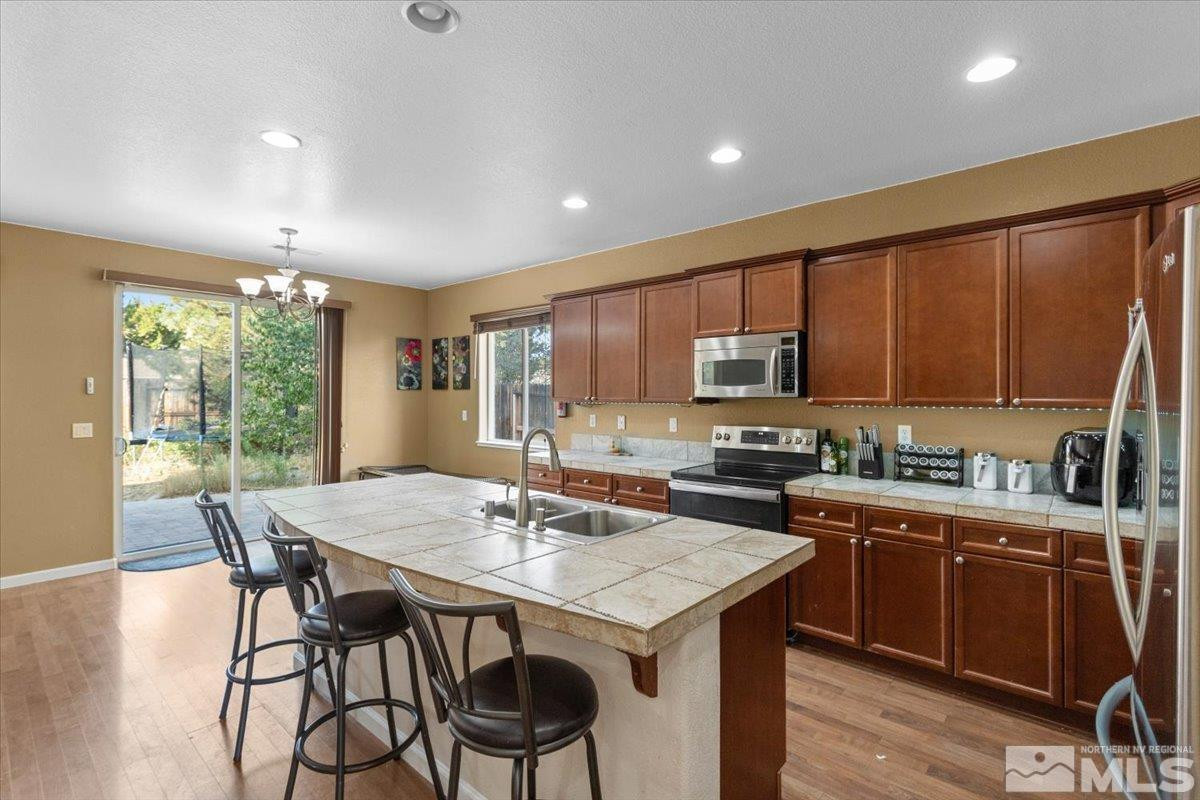 2540 Perryville Drive Reno, NV 89521 - Photo 5 of 27 a kitchen with a dining table chairs and refrigerator