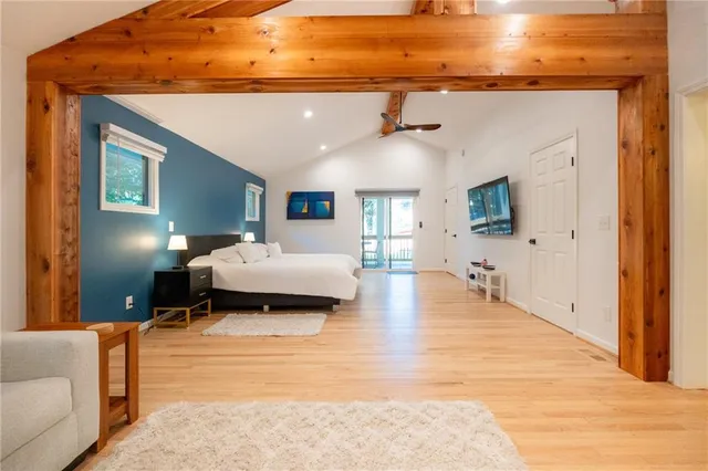 a spacious bedroom with a bed a mirror and dresser