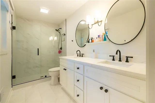 a spacious bathroom with a double vanity sink mirror and toilet