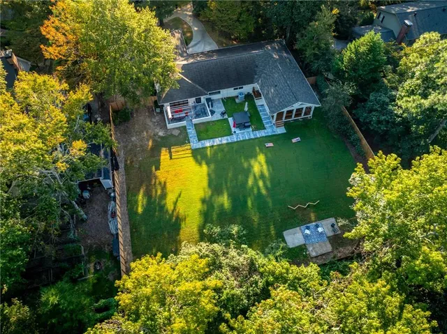 an aerial view of residential houses with outdoor space and trees