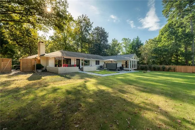 a front view of house with yard and trees in the background