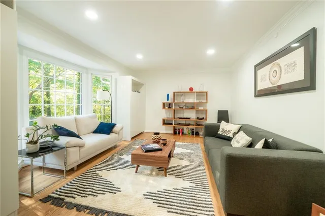a living room with furniture a rug and a large window