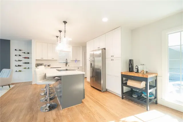a large kitchen with a table chairs refrigerator and cabinets