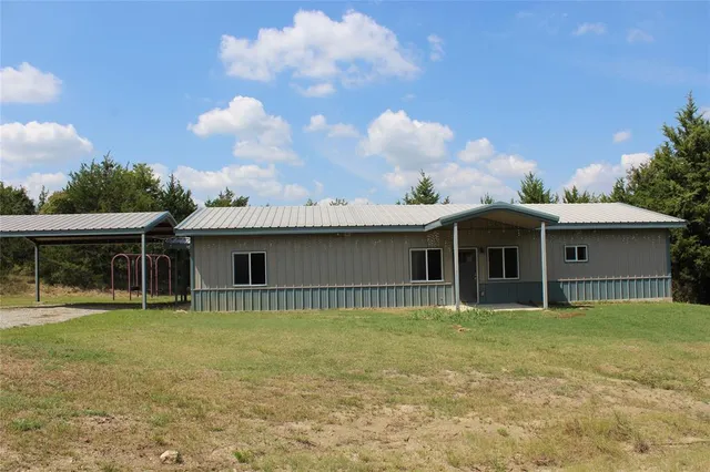 a view of a house with yard and sitting area