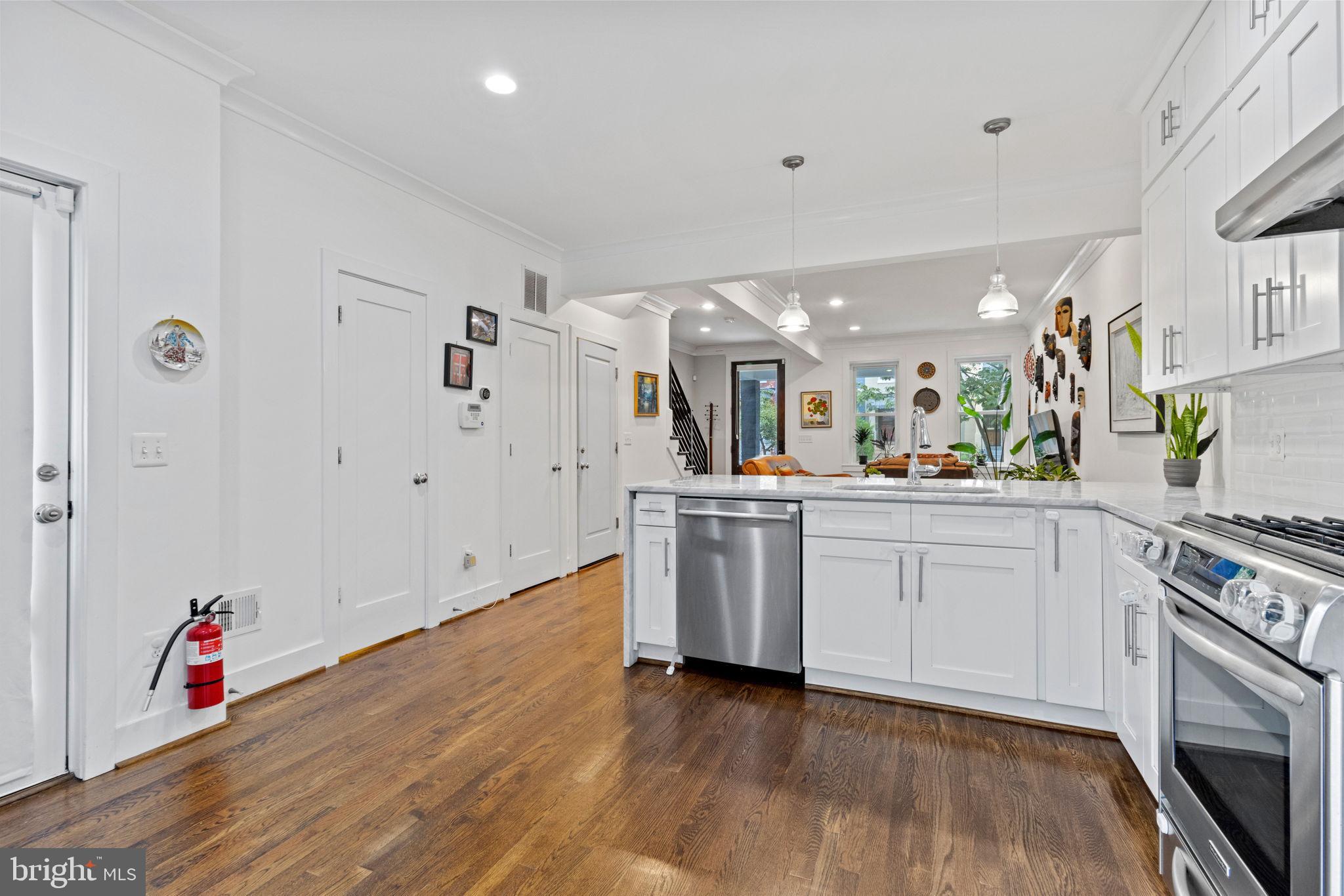 1928 First Street Northeast Washington, DC 20002 - Photo 11 of 26 a kitchen with white cabinets and wooden floor