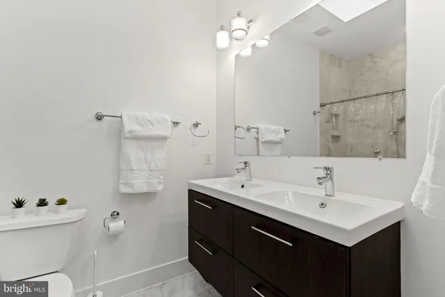 a bathroom with a sink a toilet and a mirror