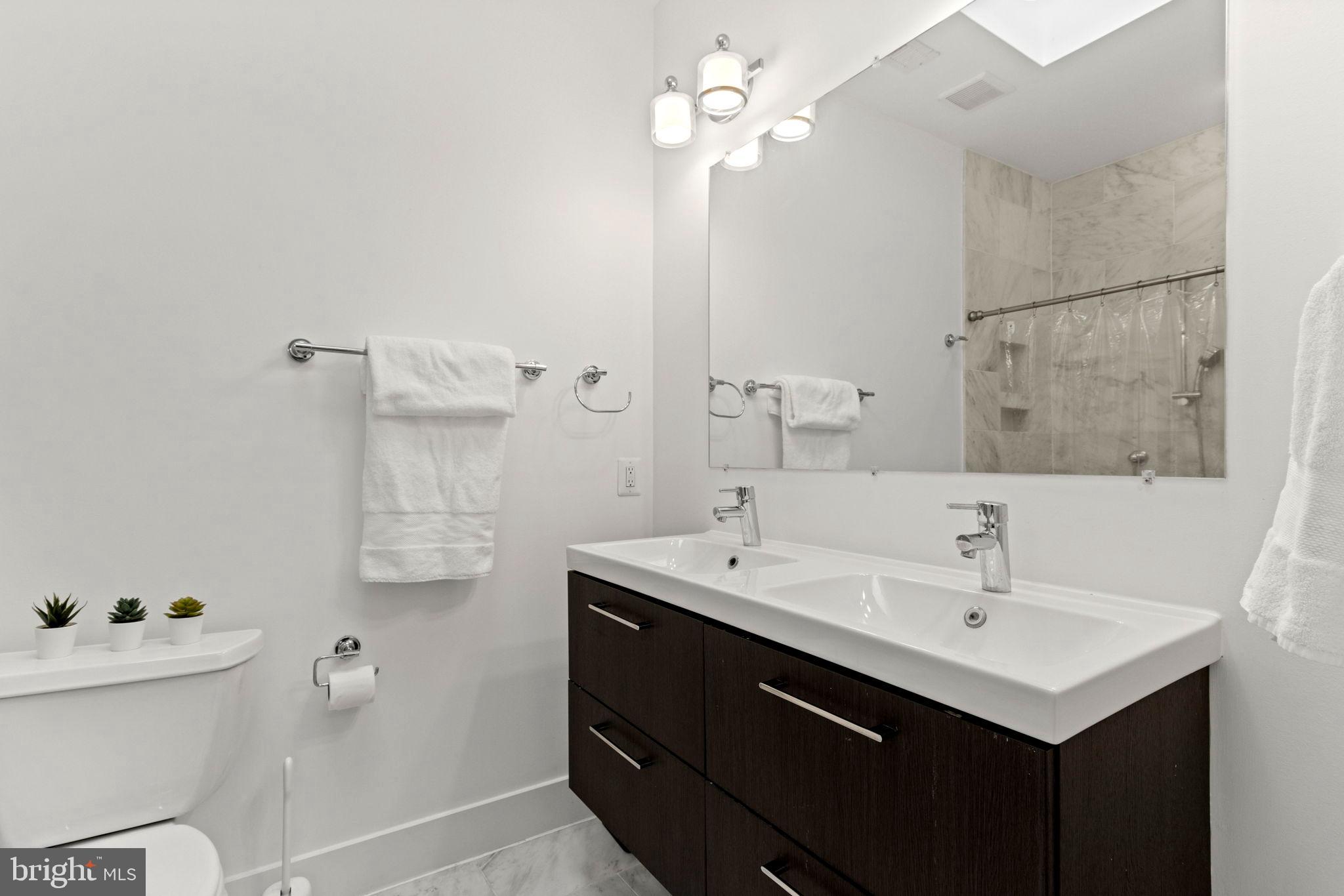 1928 First Street Northeast Washington, DC 20002 - Photo 19 of 26 a bathroom with a sink a toilet and a mirror