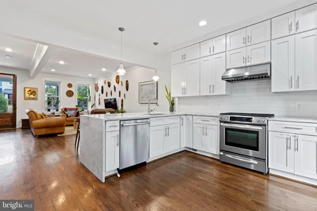 a kitchen with stainless steel appliances granite countertop a stove a sink and a refrigerator