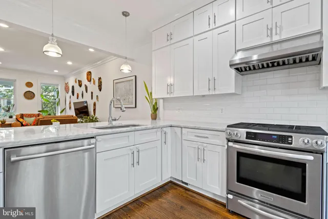 a kitchen with white cabinets and appliances