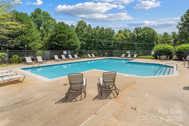a view of a house with pool and chairs
