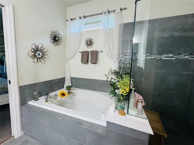 a bathroom with a tub sink and mirror