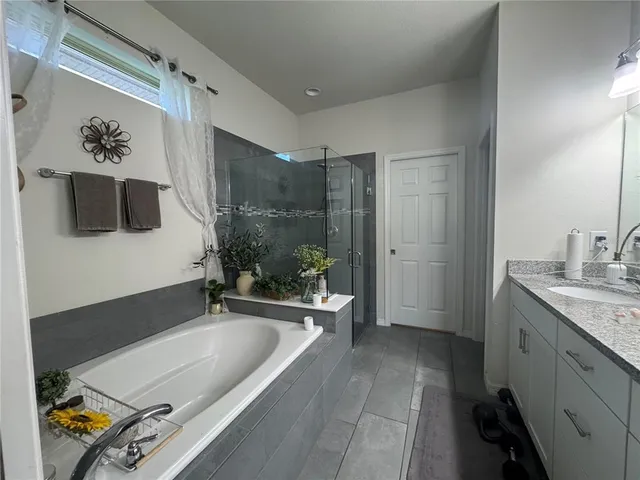 a bathroom with a tub a sink and glass door