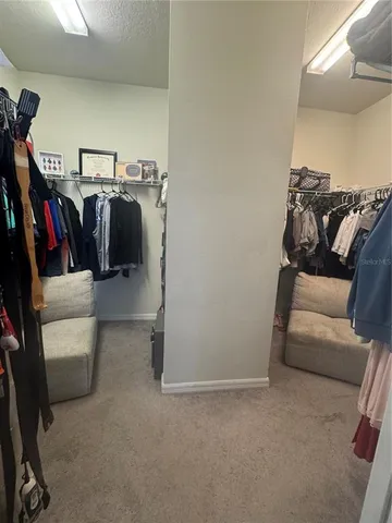 a view of walk in closet with clothes and shoes