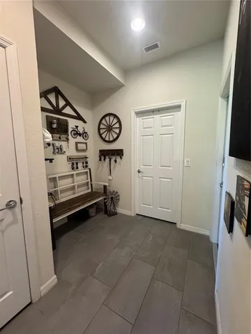 a view of a storage & utility room with a fridge
