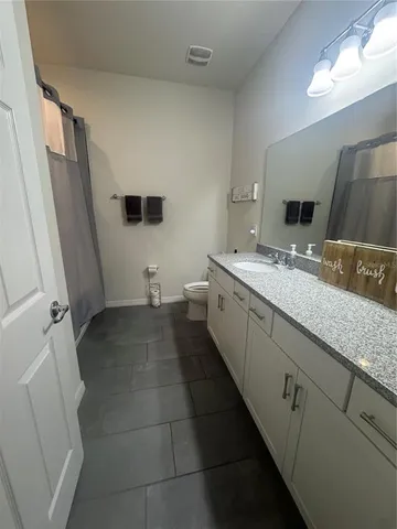 a bathroom with a granite countertop sink and mirror