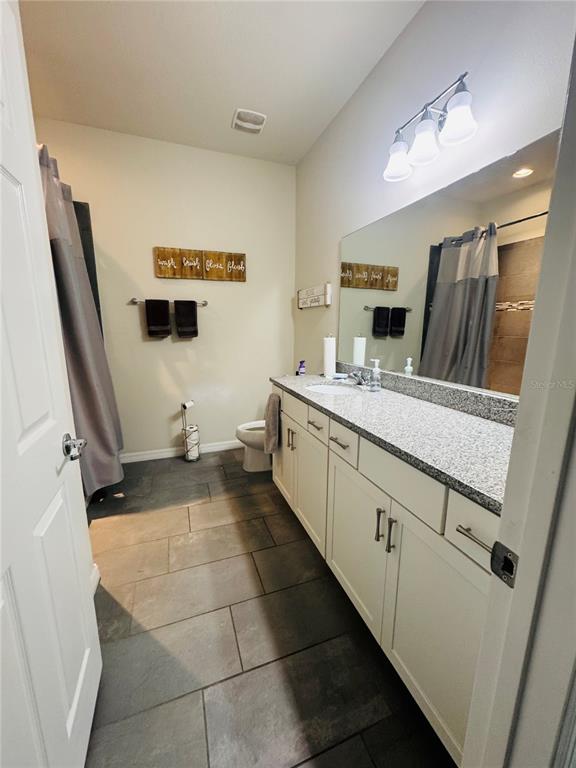 11626 Dublin Grafton Riverview, FL 33579 - Photo 8 of 32 a bathroom with a sink a toilet and mirror