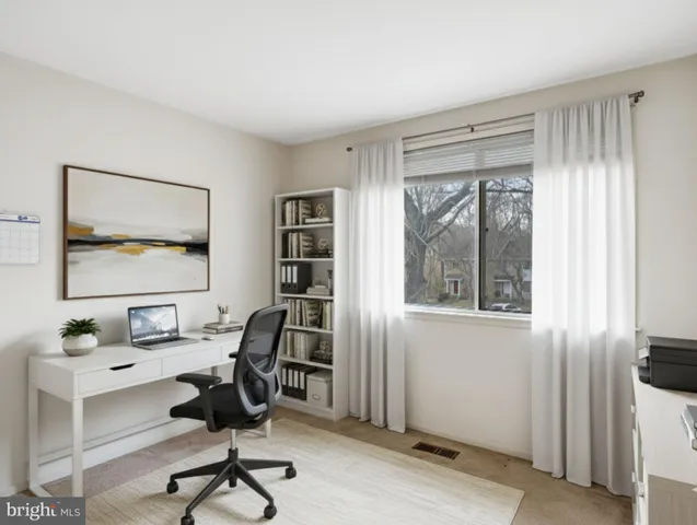 a view of a workspace with furniture and a window