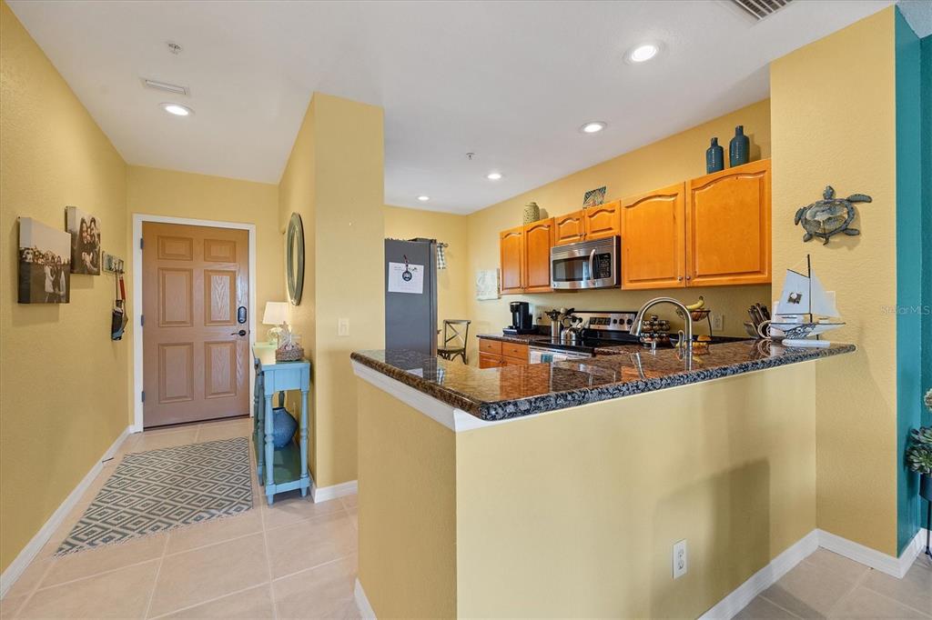 8413 Placida Road, Unit 407 Placida, FL 33946 - Photo 8 of 57 a kitchen with stainless steel appliances granite countertop a sink a stove and a refrigerator