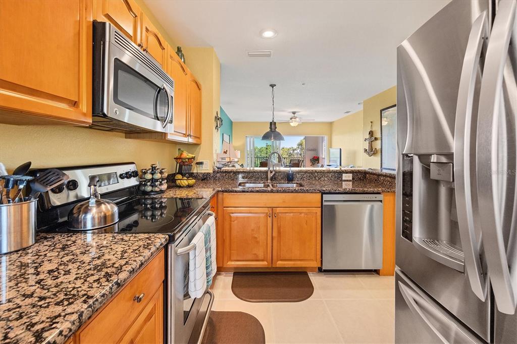 8413 Placida Road, Unit 407 Placida, FL 33946 - Photo 9 of 57 a kitchen with stainless steel appliances granite countertop a refrigerator a stove and a sink with cabinets