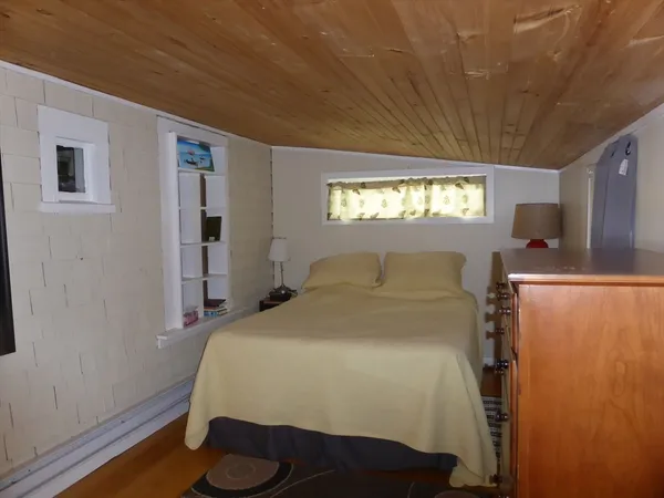 a bed sitting in a bedroom next to a window