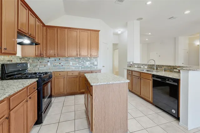 a kitchen with a stove sink and cabinets