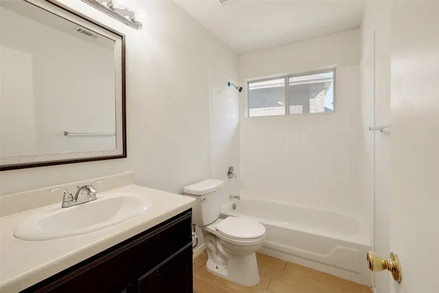 a bathroom with a granite countertop sink toilet a mirror and shower