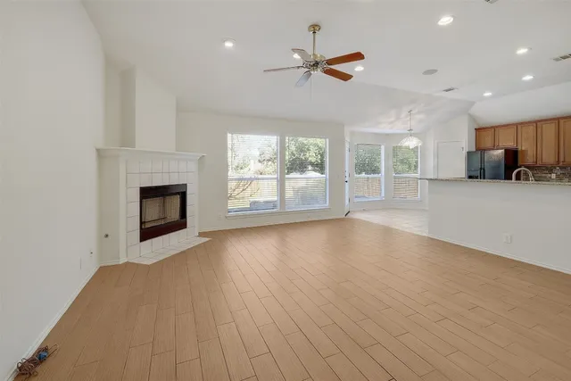 an empty room with windows and fireplace
