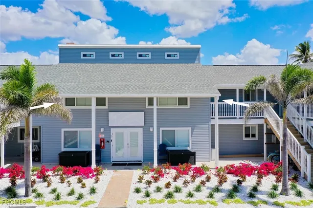 a kitchen with stainless steel appliances kitchen island granite countertop a sink dishwasher a dining table and chairs with wooden floor