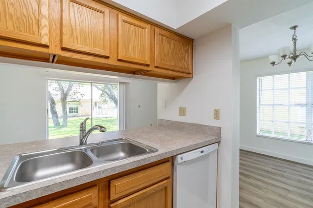 a kitchen with stainless steel appliances granite countertop a sink a cabinets and a window