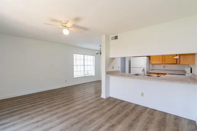 a view of a kitchen with wooden floor and window