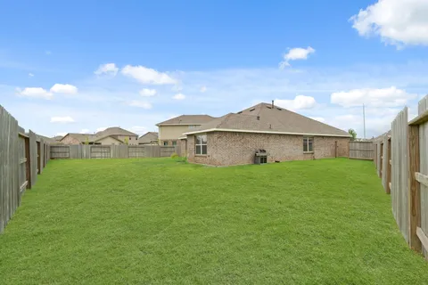 a view of a house with a big yard and a large tree