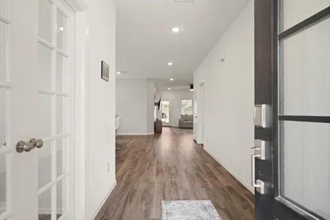 a view of a hallway with wooden floor