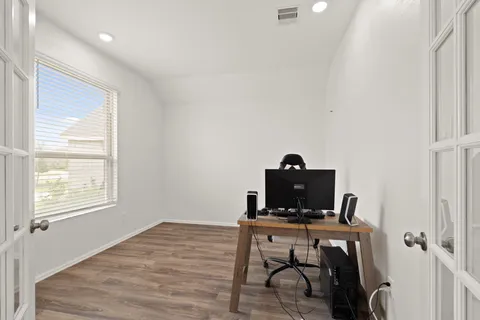 a view of a workspace with furniture and a window