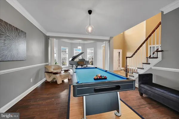 a living room with furniture pool table and window