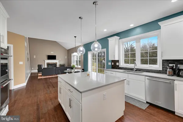 a large kitchen with stainless steel appliances a lot of counter space and a wooden floors